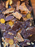 A tray of chocolate-covered matzo pieces mixed with chocolate coins and nuts.