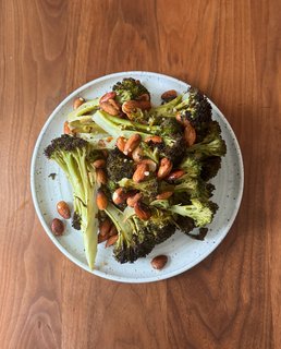 A plate of roasted broccoli topped with almonds.